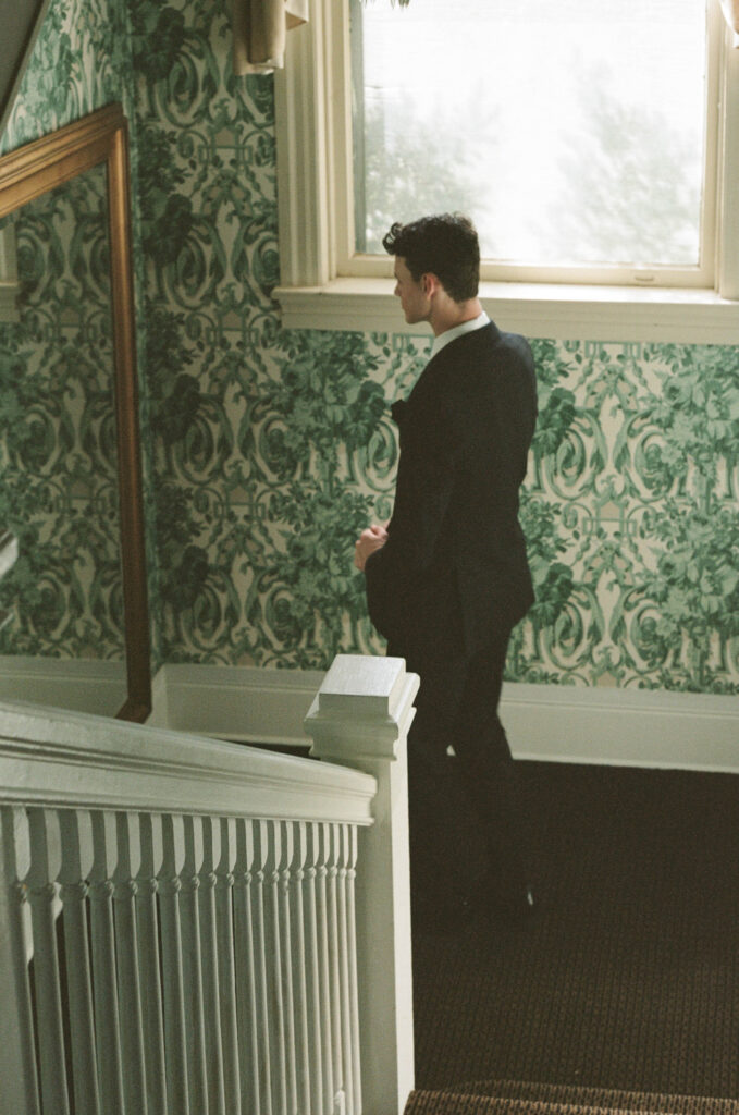 Groom looking in mirror as he goes downstairs
Refined Missouri backyard wedding — groom preparing and checking his reflection, intimate moment photographed by Emily Ambie.
