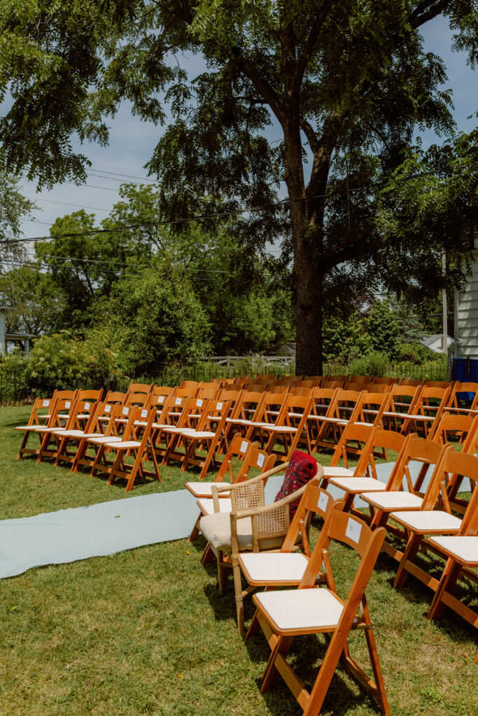 wooden chairs line aisle for intimate backyard wedding in columbia missouri