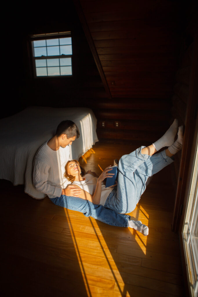 Editorial engagement photography in Utah capturing a couple in cozy sweaters at a snowy cabin