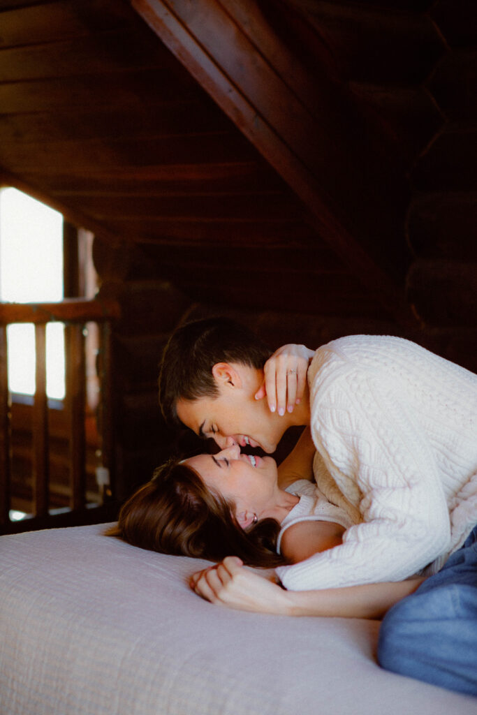 Couple laughing together in snowy Utah cabin editorial engagement photography