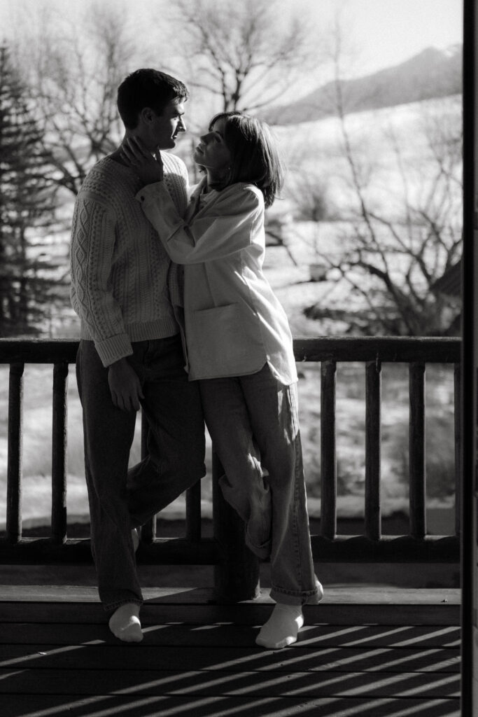 Cozy, snowy editorial engagement photography in Utah with cabin and mountain backdrop