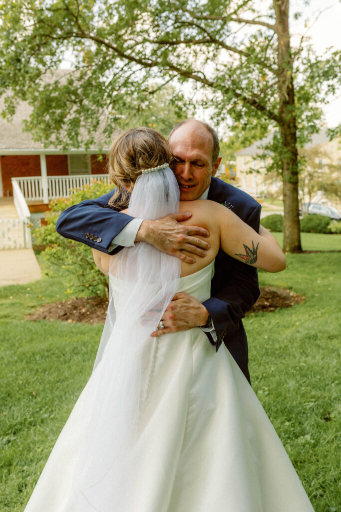 Bride and dad hugging in backyard garden
Elegant backyard wedding in Missouri with intimate, presence-driven ceremony captured by Emily Ambie.