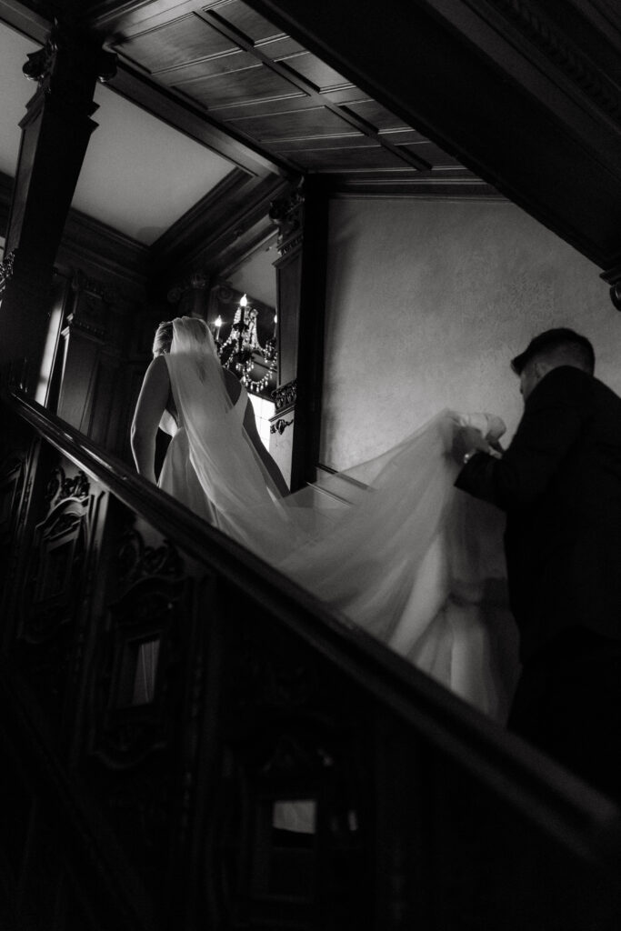 bride and groom walking up marble stairs at Loose Mansion – elegant editorial wedding photo with documentary approach