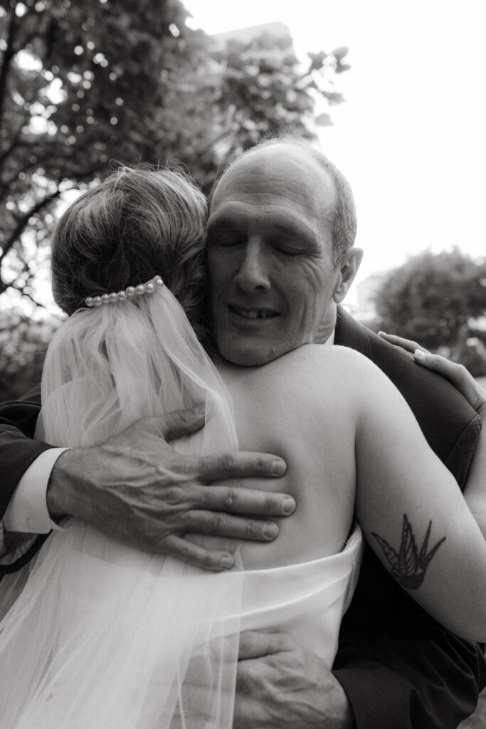 intimate destination wedding moment of dad hugging bride; Oregon Coast photographer