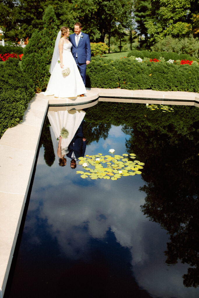 bride and groom reflection in lily pad pond – artful loose editorial wedding photography